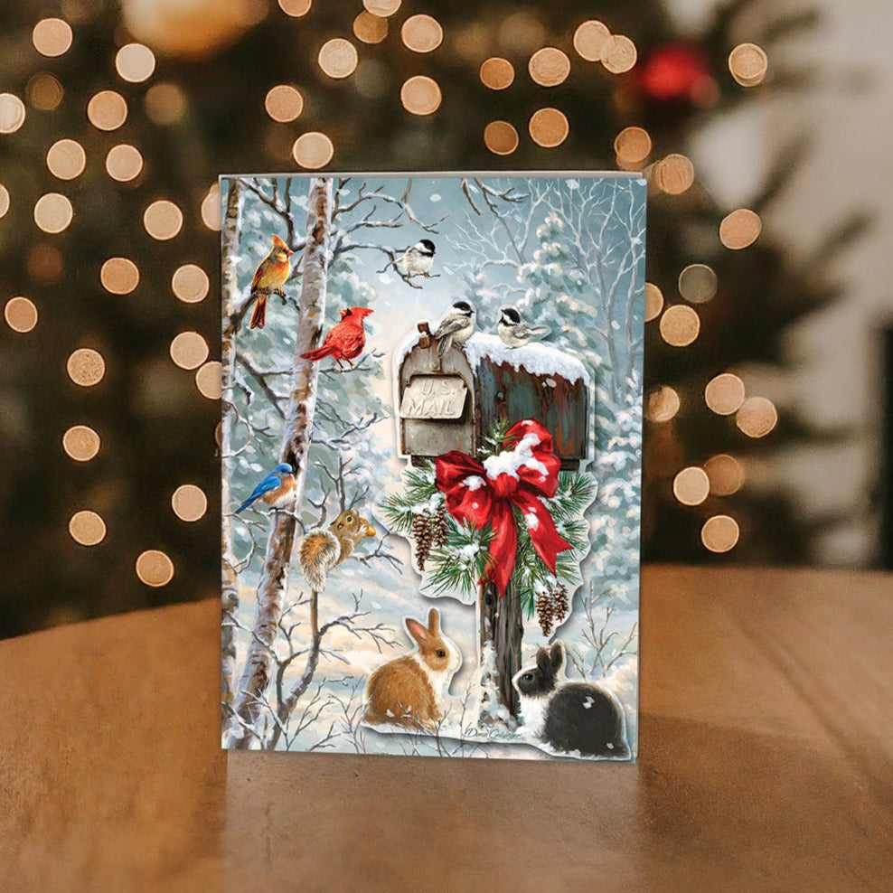 Christmas Tidings - Boxed Christmas Cards on a table with a Christmas Tree in the background