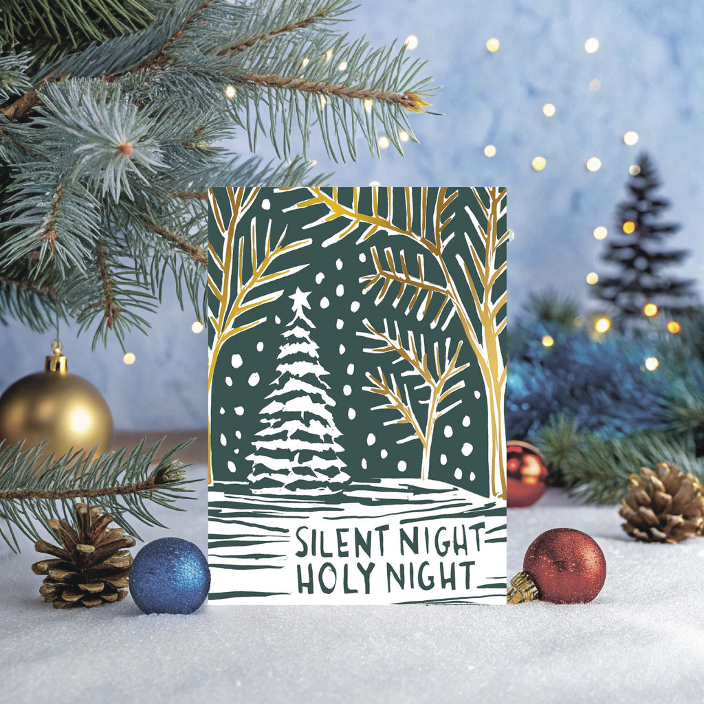 Christmas card with 'Silent Night Holy Night' text and winter scene design, surrounded by festive decorations.