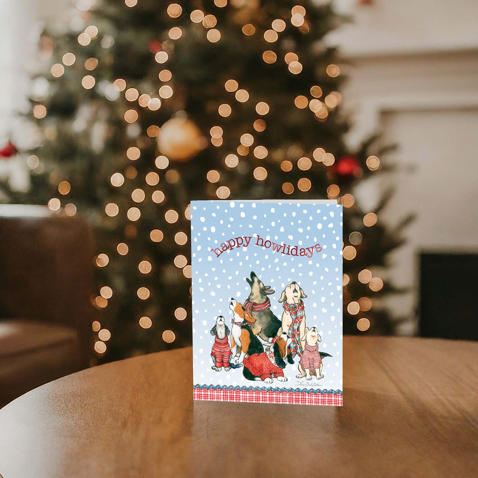 Canine Choir - 26 Special Finish Boxed Christmas Cards on a table, with a Christmas tree in the background
