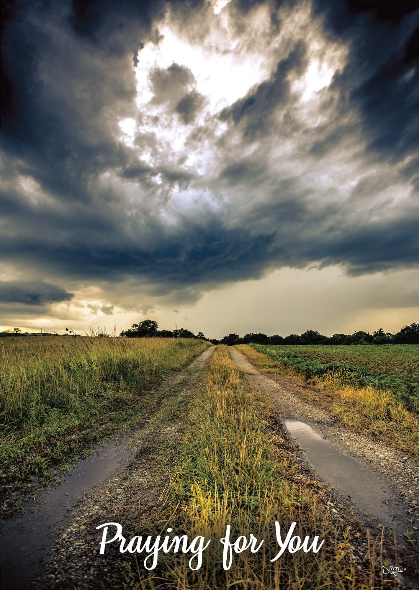 Dirt road leading into a field with a dramatic sky and 'Praying for You' text.