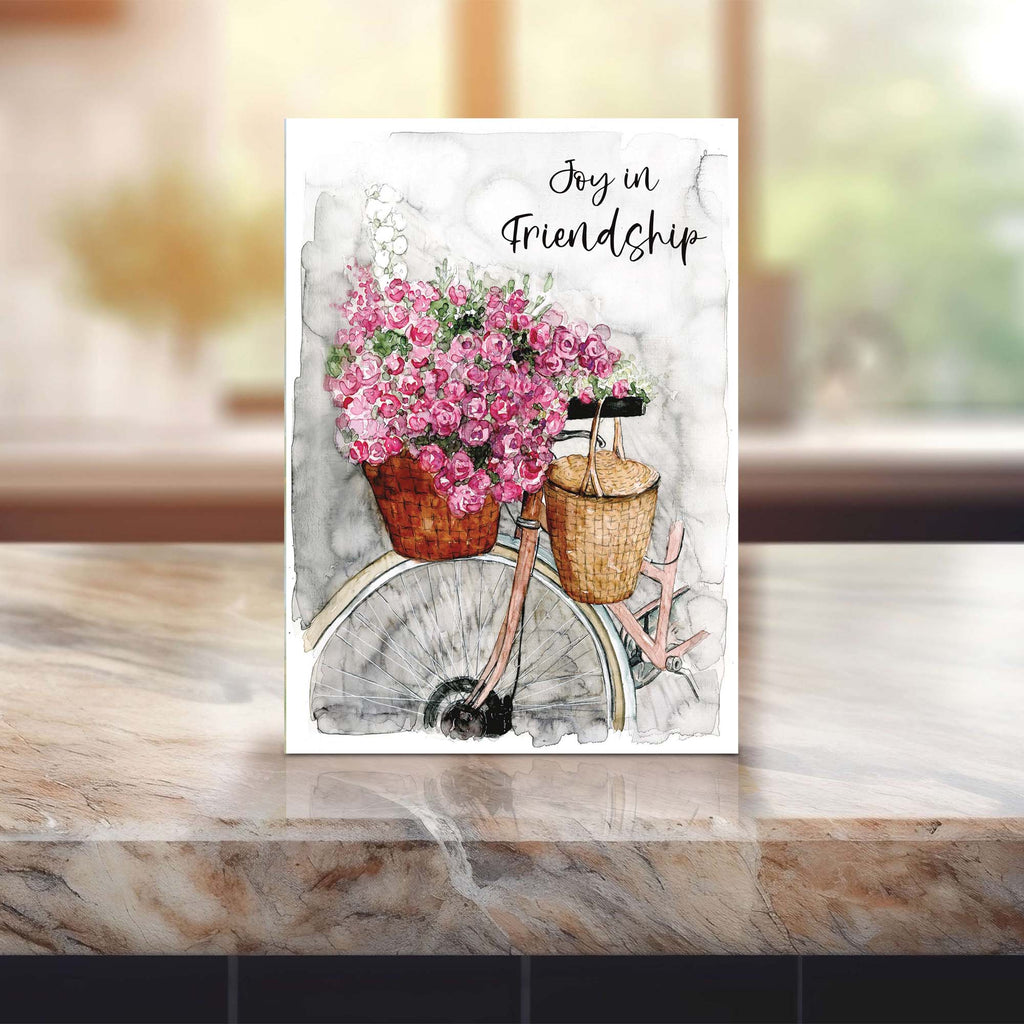 Card with bicycle and pink flowers on a marble surface
