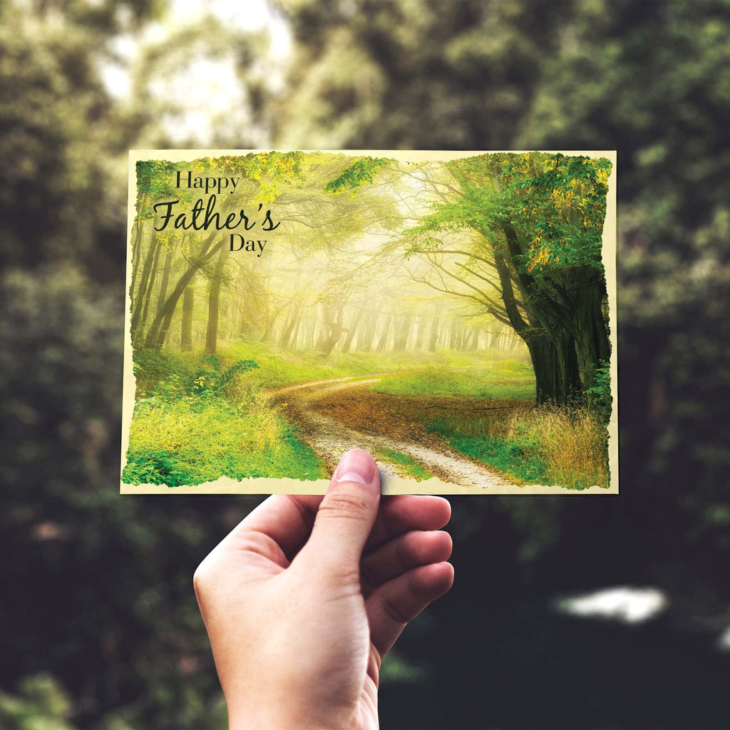 Hand holding a Father's Day card with a forest design.