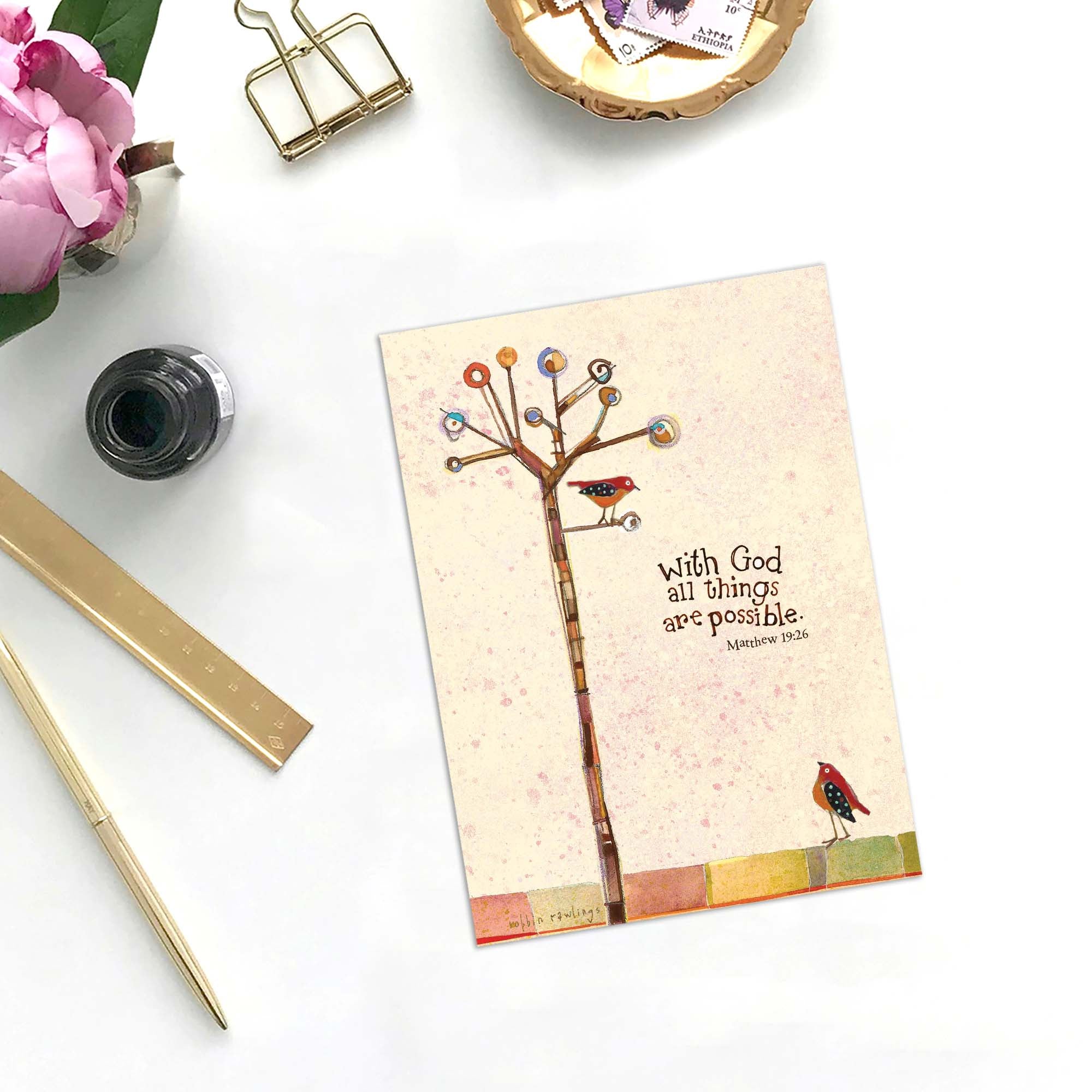 Notebook with a tree and birds illustration on a desk with stationery items