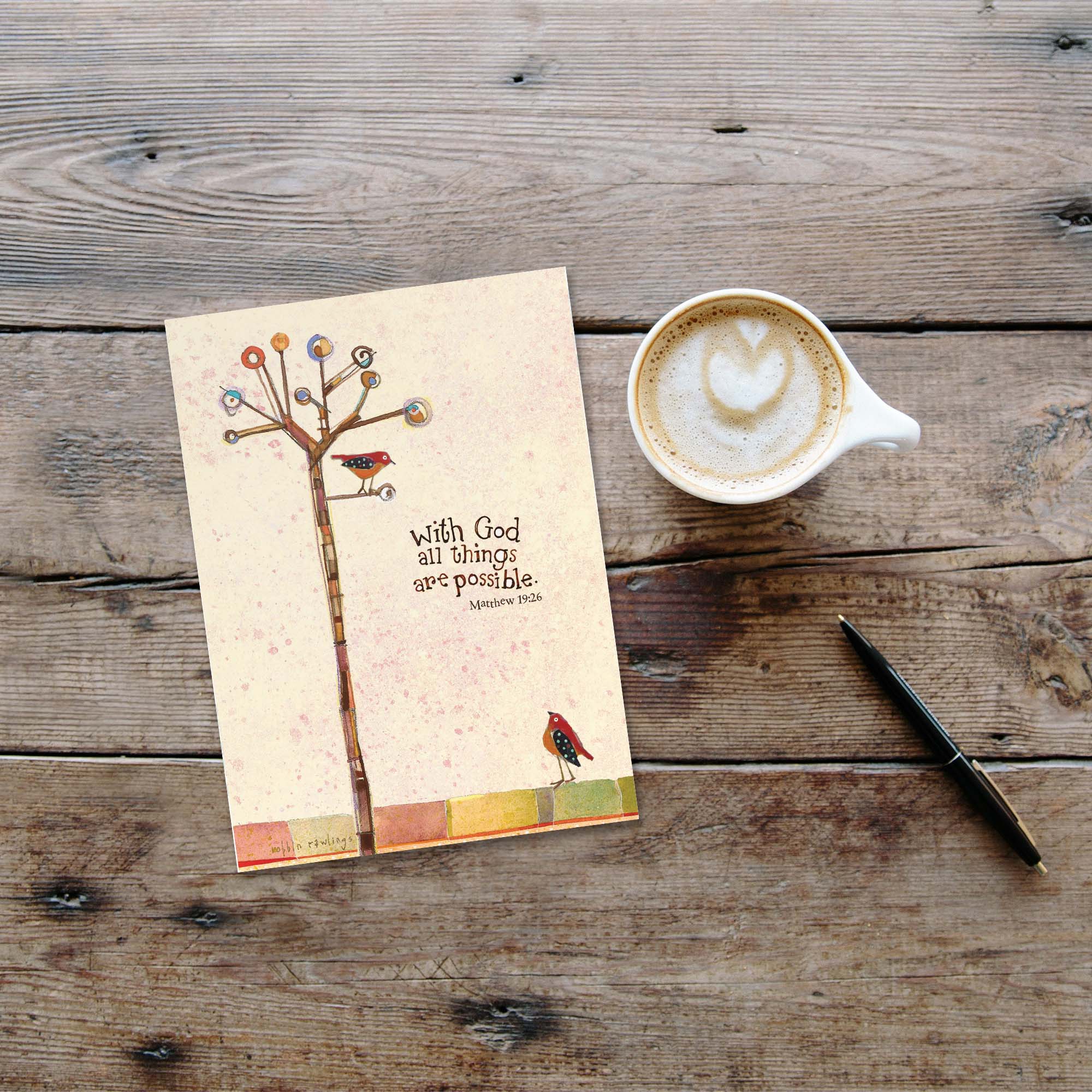 Notebook with a tree illustration and motivational quote next to a cup of coffee on a wooden surface.