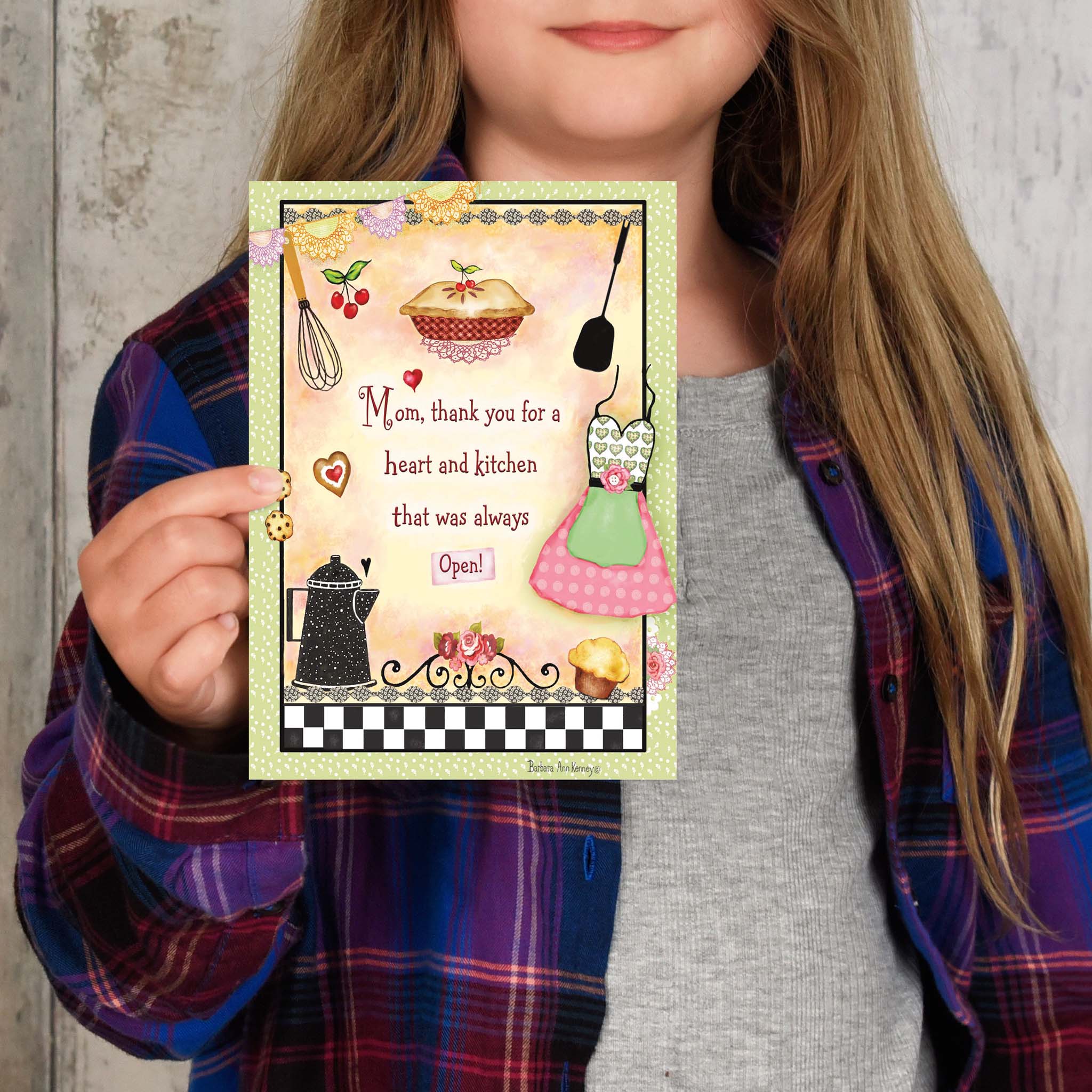 Person holding a greeting card with kitchen-themed design and text.