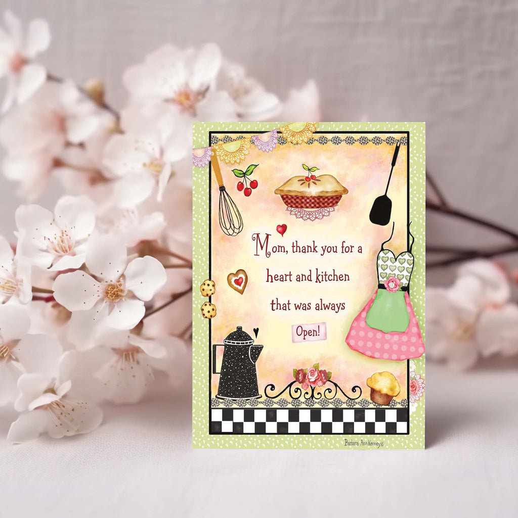 Greeting card with kitchen-themed illustrations and text, placed among white flowers.