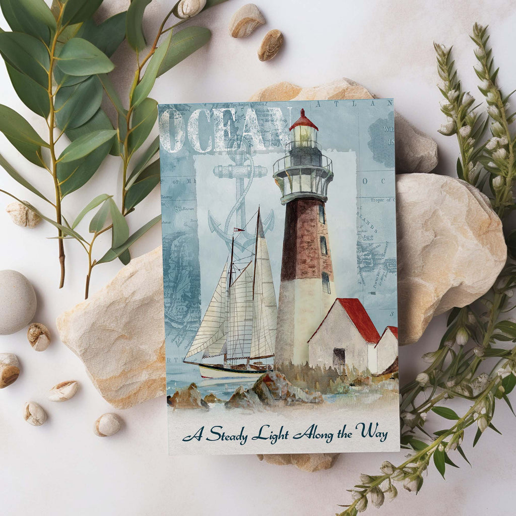 Postcard with a lighthouse and sailboat design, surrounded by stones and greenery.