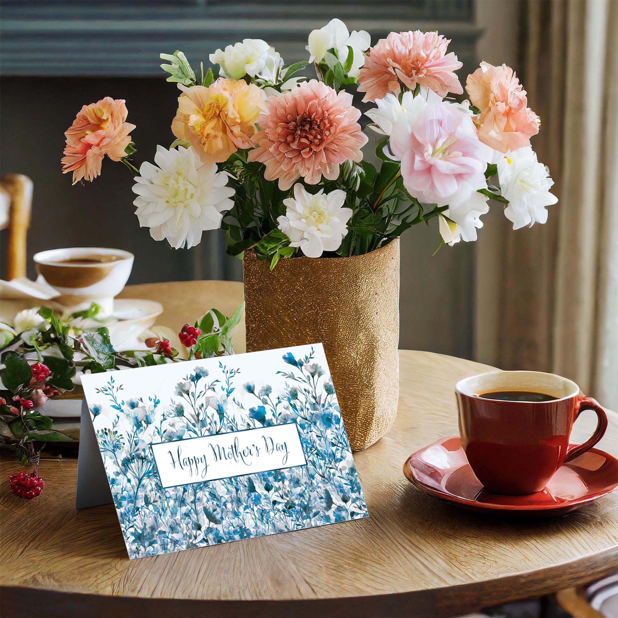 Vase of flowers, 'Happy Mother's Day' card, and coffee cup on a table.